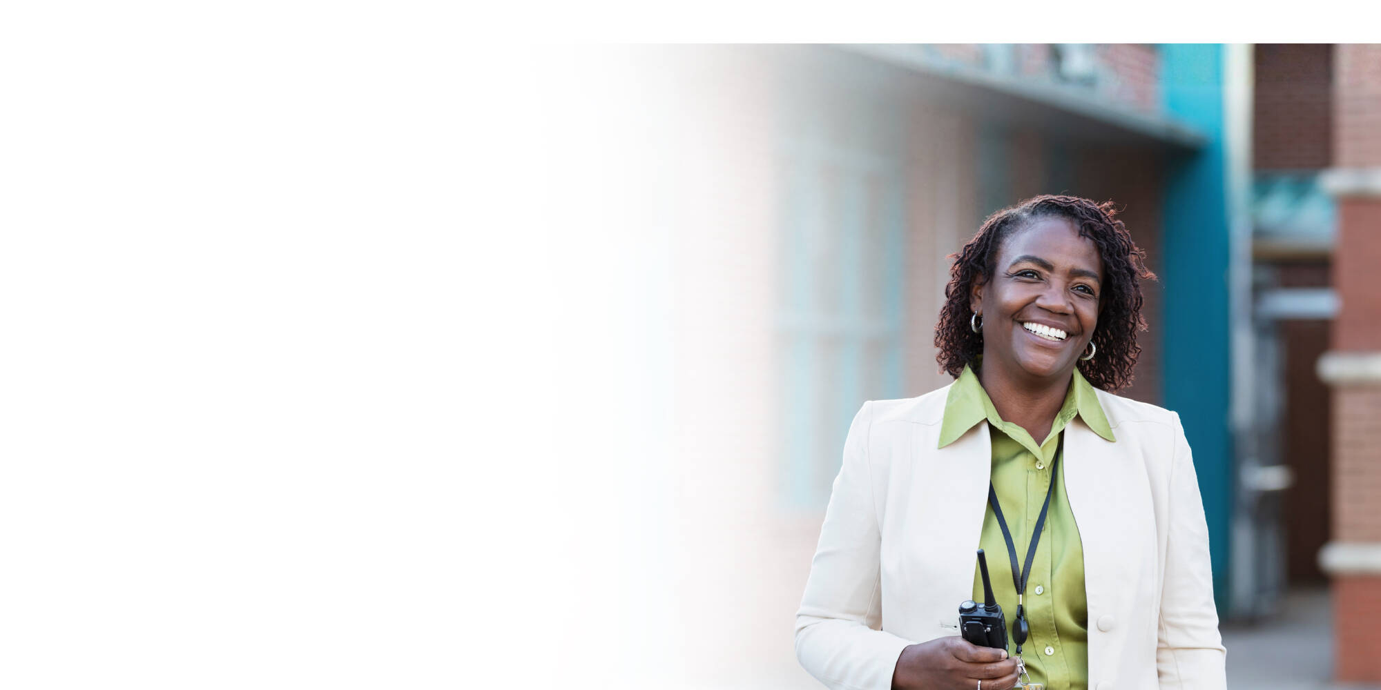 Smiling educator standing outside school building